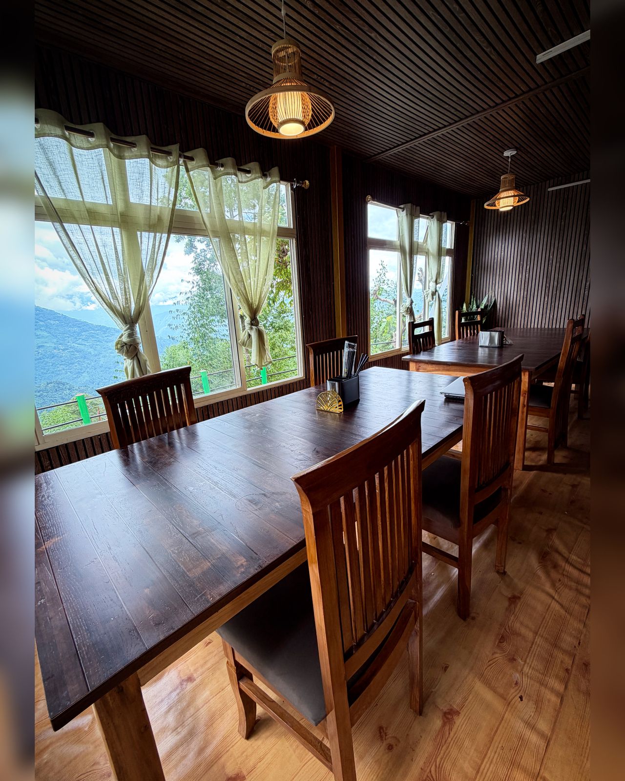 Wood-panelled dining room with Teesta valley view at Kepchaki Stay homestay, Lamahatta
