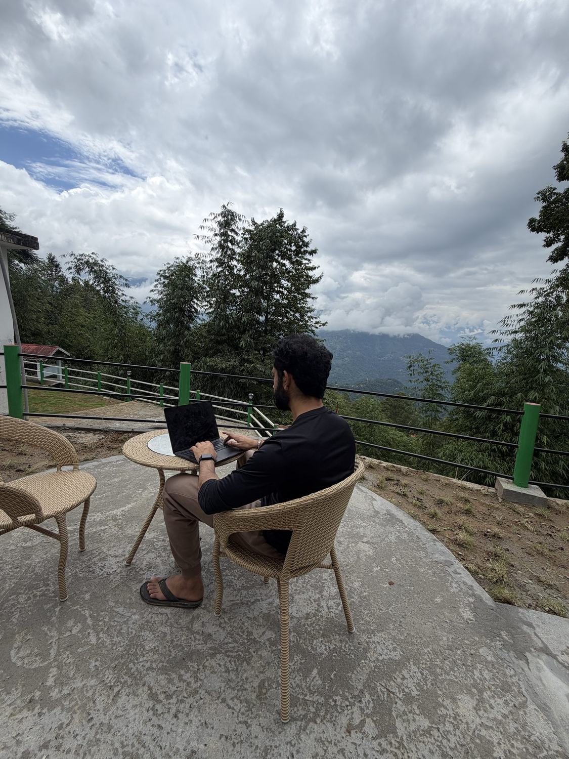 Guest working on a laptop at the valley-view terrace — workation at Kepchaki Stay, Lamahatta